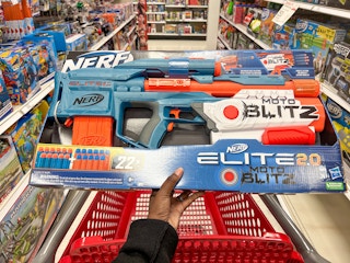 hand holding nerf blaster above cart