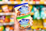 hand holding blue diamond almond cans