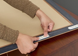 a person putting Command strips on a picture frame