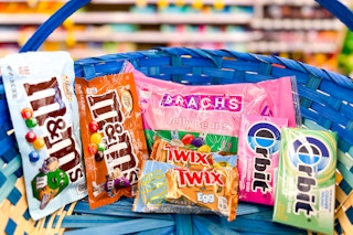 a blue easter basket with m&ms, brachs, twix, and orbit