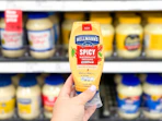 hand holding hellman's spicy mayo in front of a target shelf
