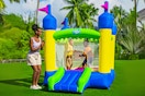 Lifestyle image of the H2OGO! Castletopia Inflatable Bounce House (outdoor setting with adult + 2 children)