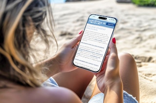 a person on their phone sitting in the sand