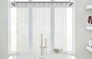 a clear shower curtain liner in front of a bathtub 