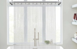 a clear shower curtain liner in front of a bathtub