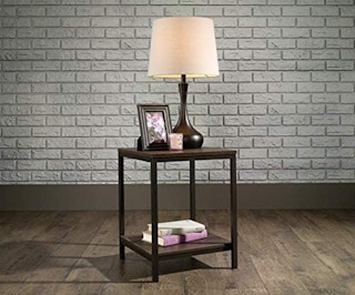 wooden side table with a lamp on it in a room