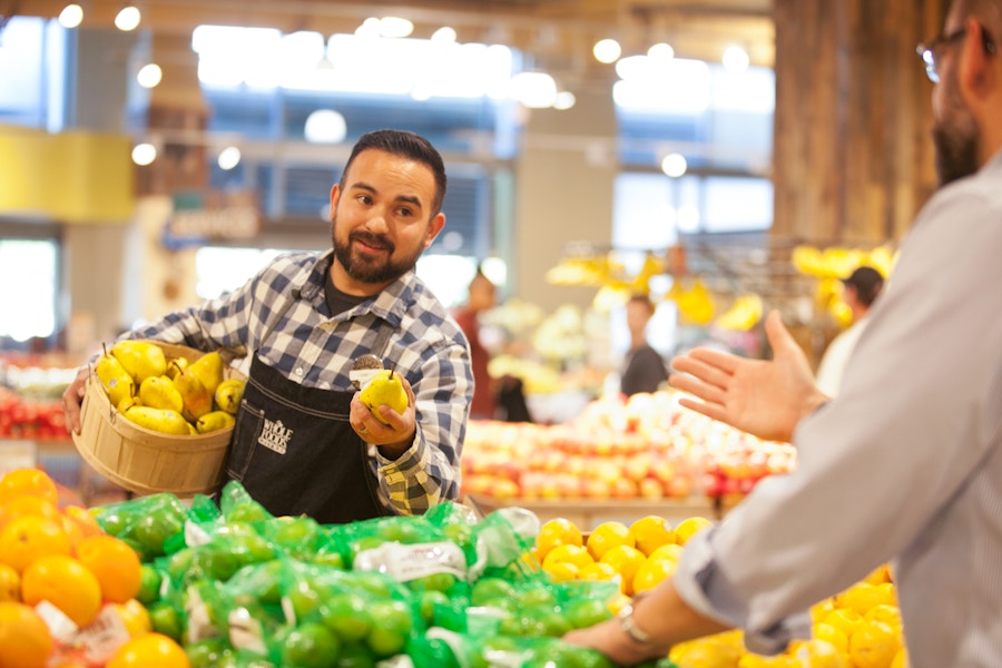 A Whole Foods employee helping a customer