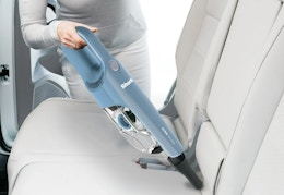 shark handheld vacuum being used in a car