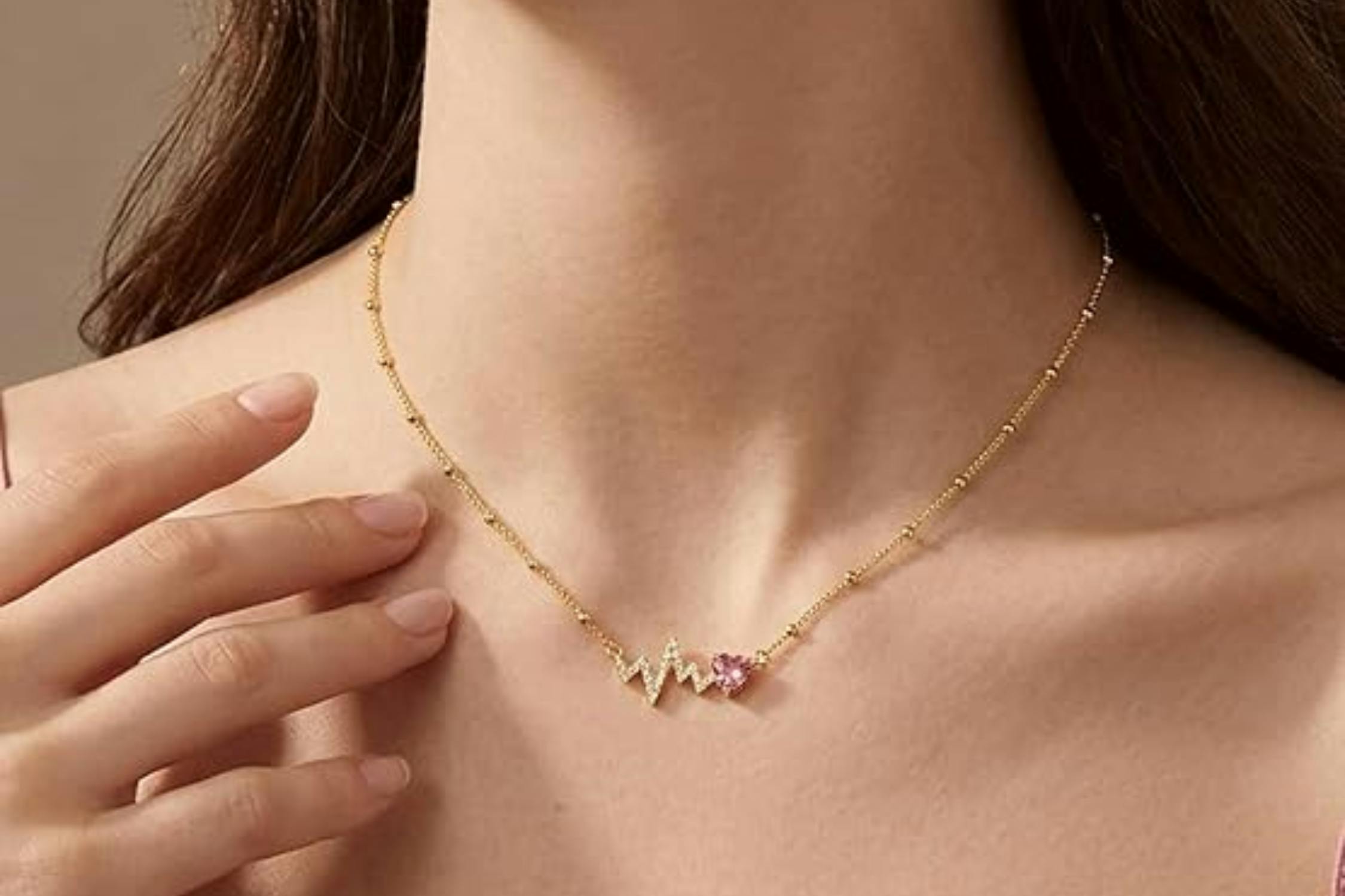 woman wearing pink heart necklace