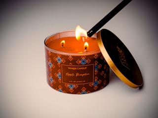 Yankee candle being lit with a lighter