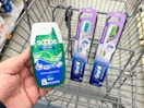 hand holding crest and oral-b items in walgreens cart