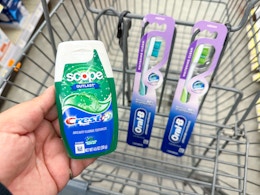 hand holding crest and oral-b items in walgreens cart