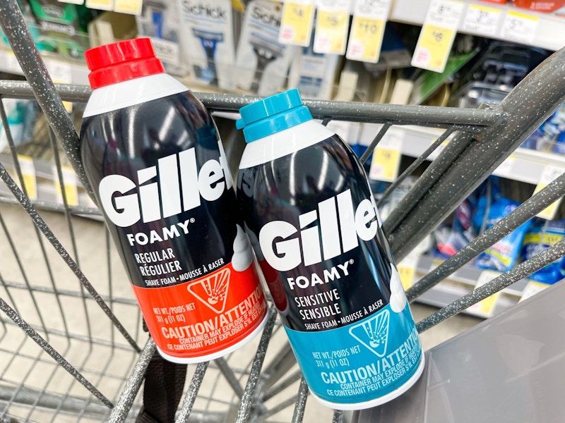 A couple bottles of Gillette Shaving Cream sitting in a store cart.