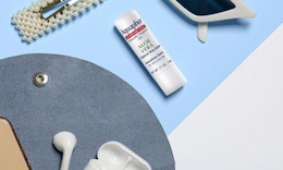 a tube of chapstick next to sunglasses and a hair clip