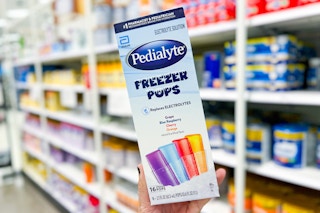 Hand holding a Pedialyte Freezer Pops Variety Pack at Target
