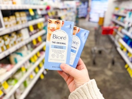 person holding 2 packages of biore pore strips in an aisle
