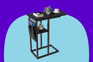 A black c-shaped sofa table has a shelf about 6 inches under the table, plus pockets on the outside end. Inside end is curved.