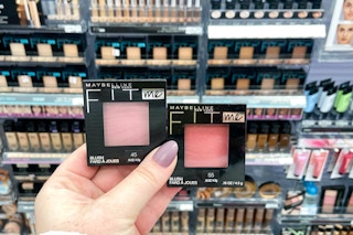 hand holding two Maybelline Fit Me Blush products