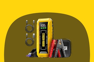 A yellow rectangular jump starter has a red clamp and a black clamp for use on a car battery. It also has 2 USB cables included.