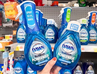Hand holding two Dawn Power Spray products in cleaning aisle at Walmart