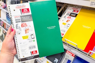 hand holding a five star notebook in front of a target shelf