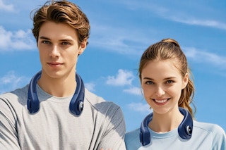 Two young people stand against a bright blue sky. Both wear a navy blue neck fan that curves around their necks like a collar.