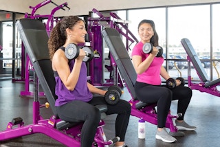 teens using free weights in a planet fitness gym