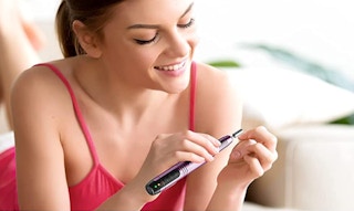a woman using an electric nail file
