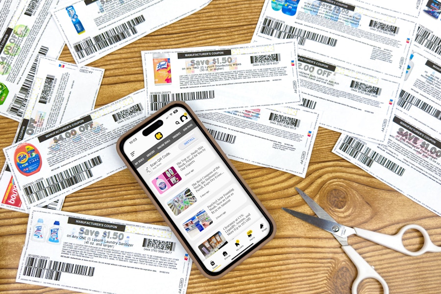 coupons on a table with a phone displaying the KCL app