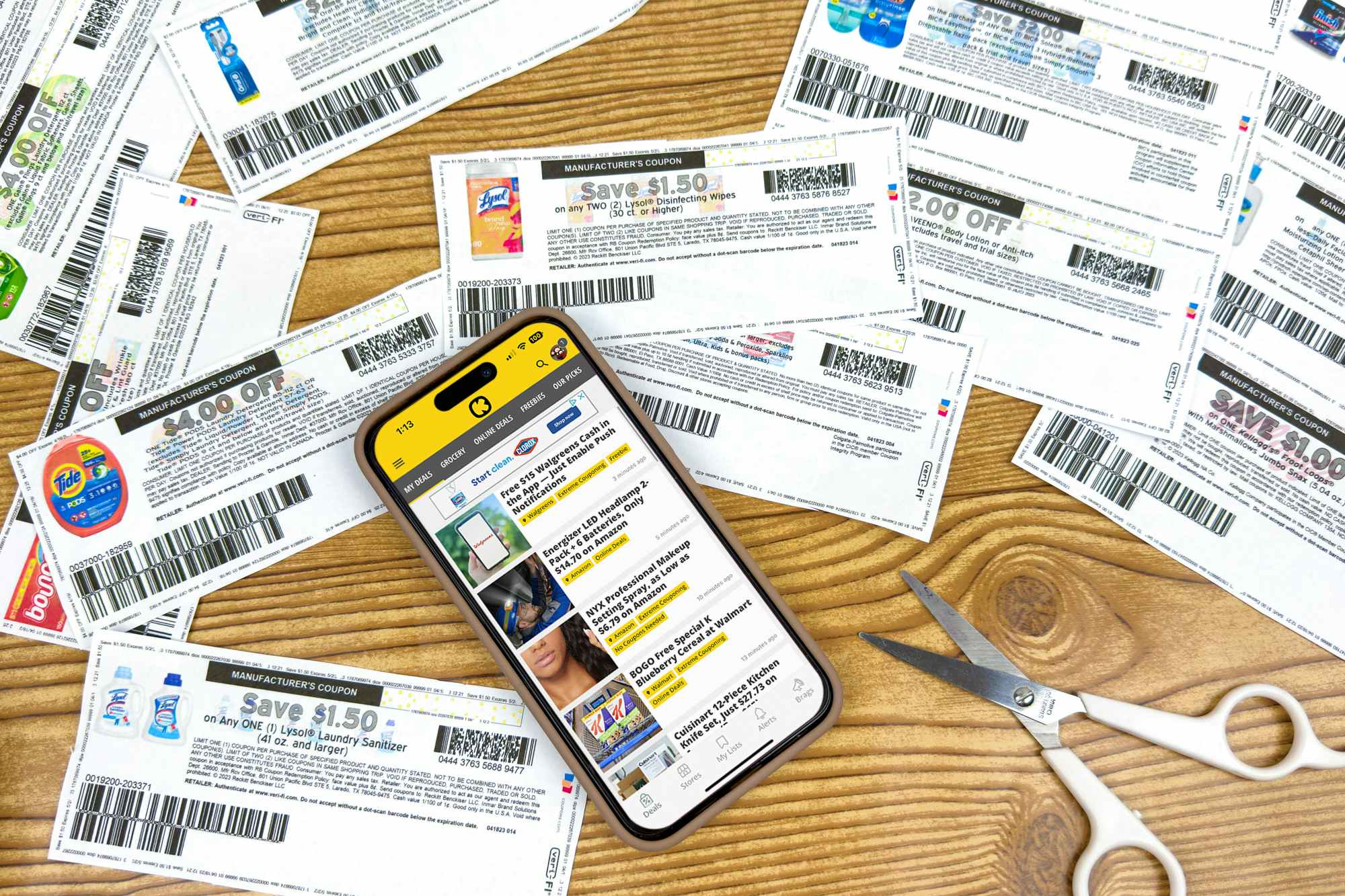 coupons on a table with a phone displaying the KCL app