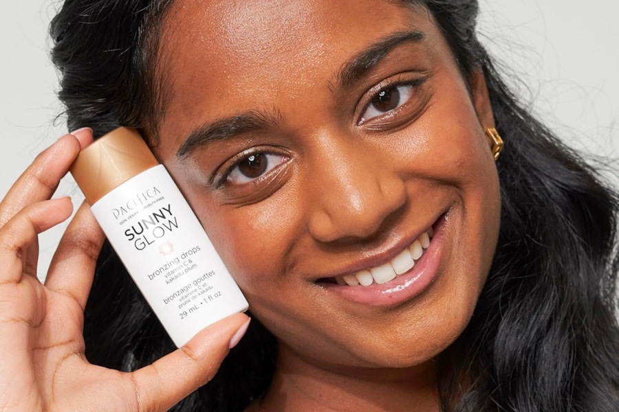 a woman holding bronzing drops