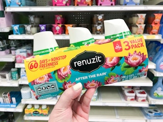 hand holding a 3-pack of renuzit gel air freshener at target
