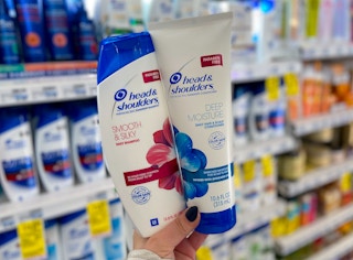 hand holding a bottle of Head & Shoulders shampoo and conditioner in aisle