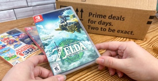Someone looking at some Nintendo Switch video games next to an Amazon Prime Day box
