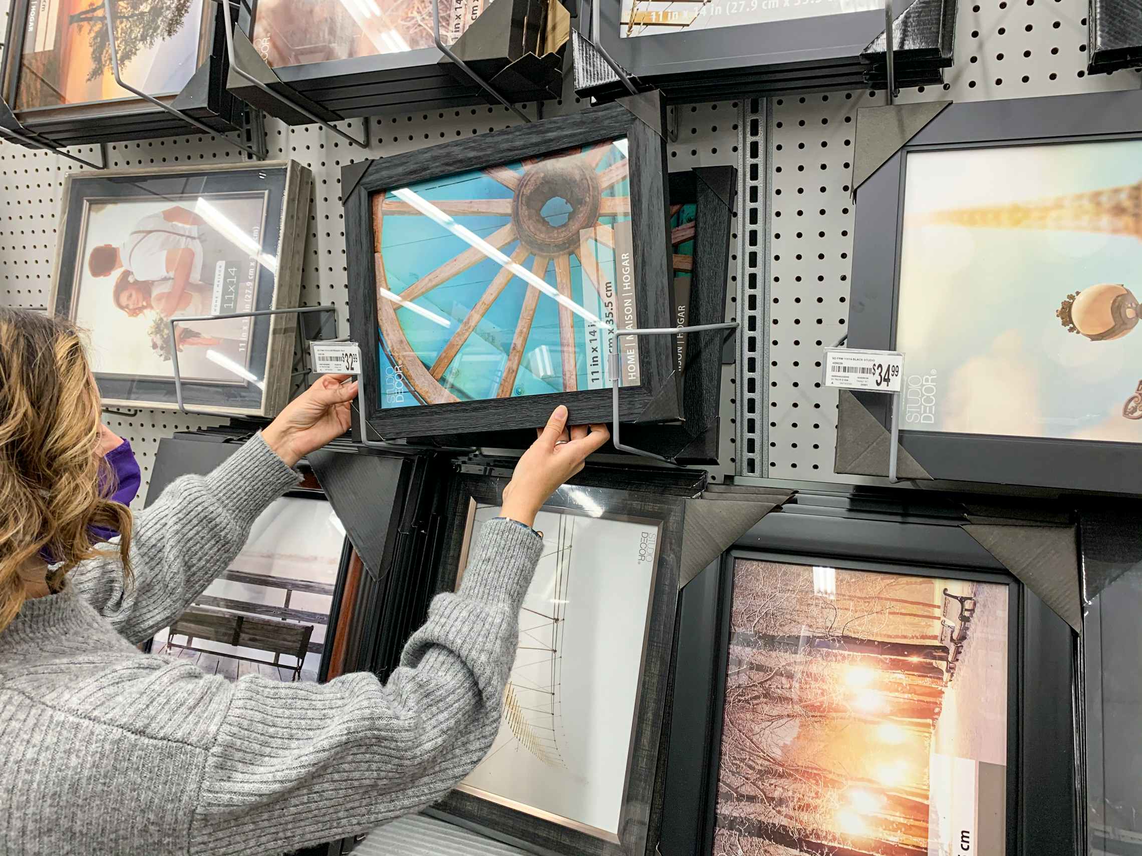 A woman looking at picture frames inside Michaels