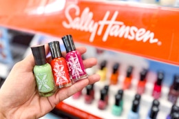 hand holding three sally hansen xtreme nail polishes