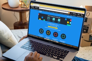 laptop on lap displaying amazon promotion with amazon boxes in background