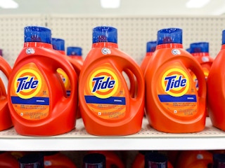 Bottles of Tide laundry detergent sitting on a shelf.