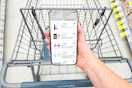 hand holding a smartphone displaying 1-clip coupon deals
