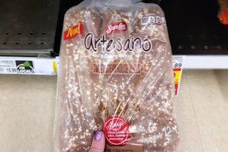 hand holding a pack of sara lee artesano rolls