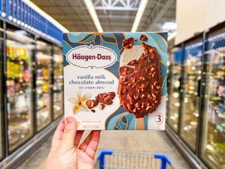 hand holding haagen-dazs ice cream bars in walmart frozen aisle