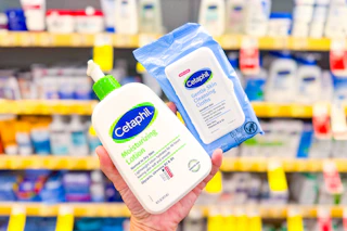 person holding cetaphil lotion and cleansing cloths