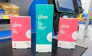 three glee body and facial hair removal products on a walmart self checkout conveyor belt