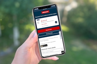 hand holding cellphone with $5 coupon on display screen