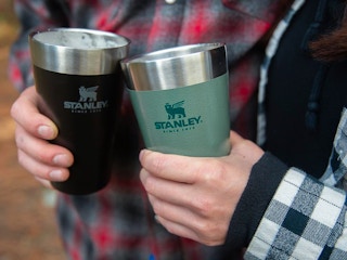 Two people holding their Stanley pint cups next to each other.