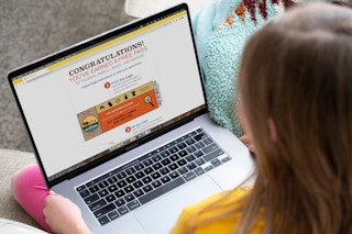 A child on a computer looking at an Every Kid Outdoors national park pass.