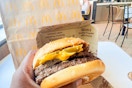 Hand holding the new quarter pounder with bacon cheese and jalepenos