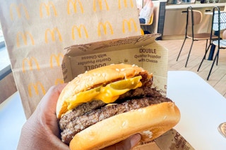 Hand holding the new quarter pounder with bacon cheese and jalepenos