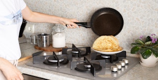 a person putting hot pancakes onto a plate