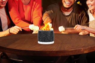 people roasting marshmellows on a tabletop fire pit